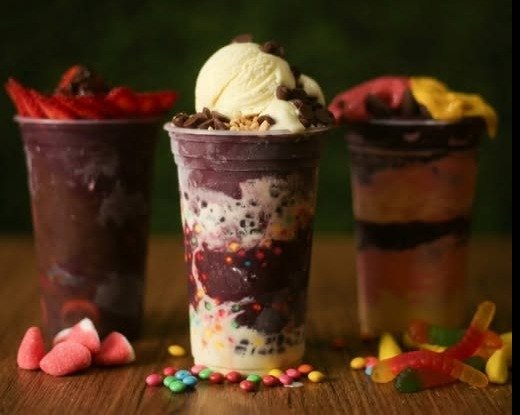 Três copos de açaí com coberturas variadas