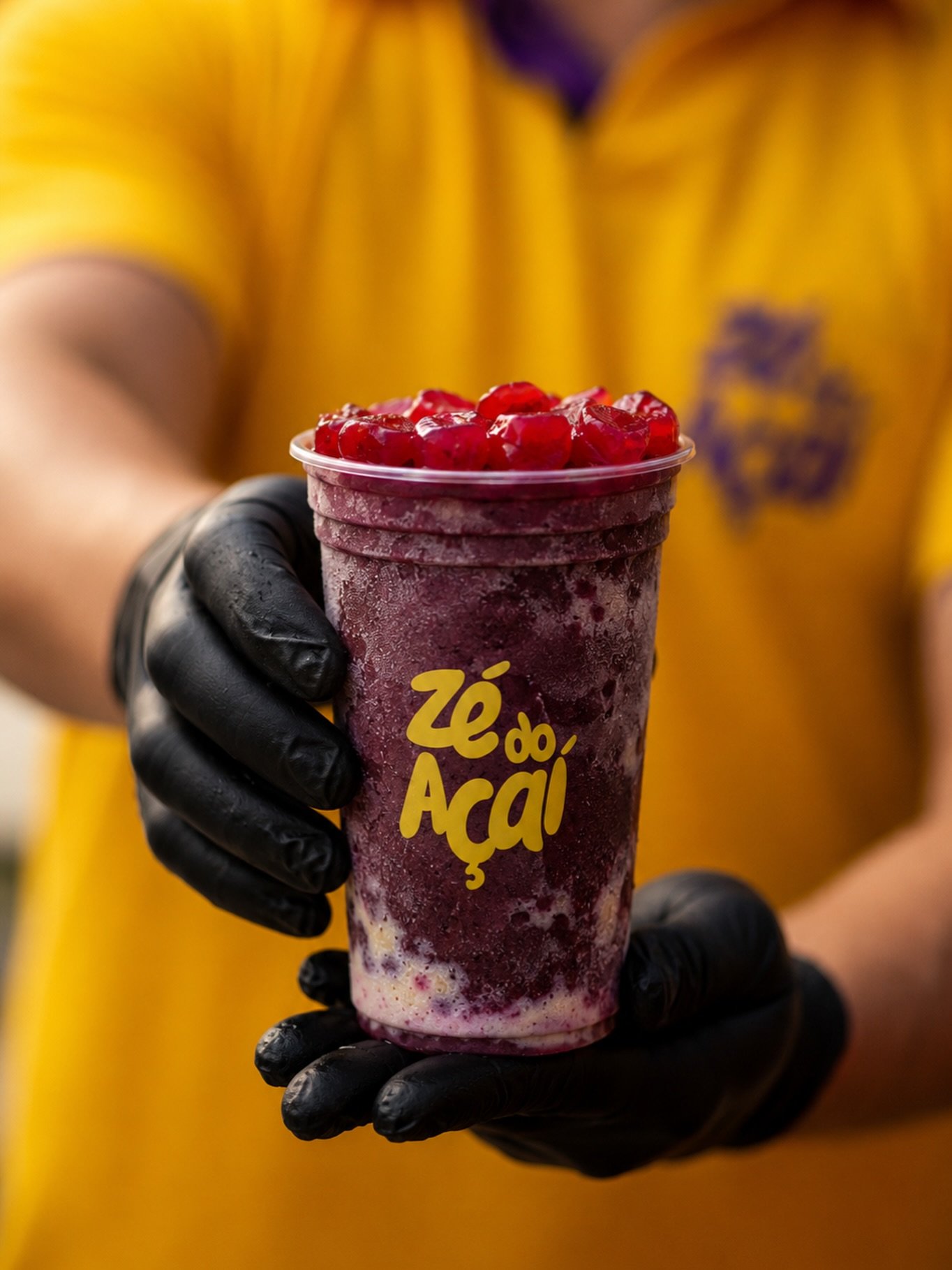 Copo da Zé do Açaí nas mãos de um atendente